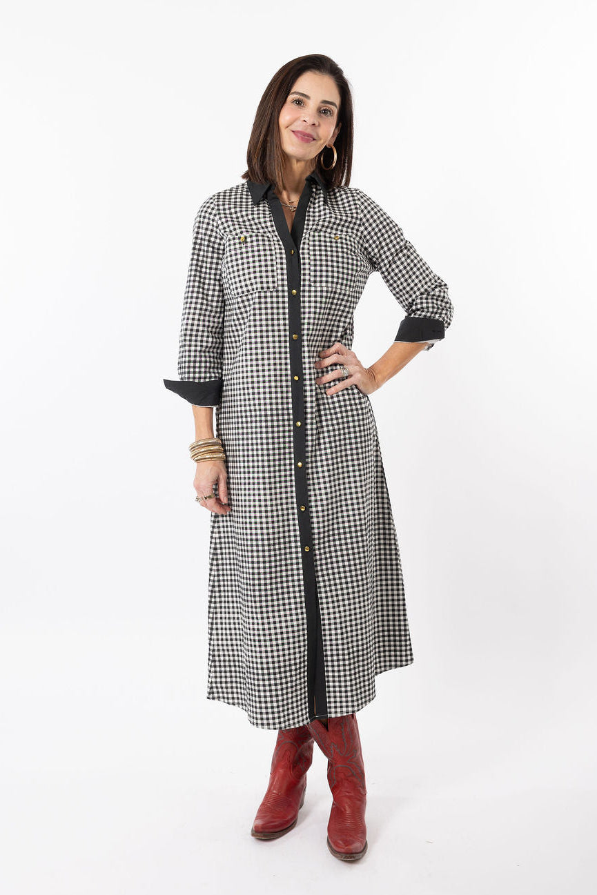 Woman wearing a black and white checkered dress with red boots on a white background
