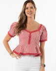 Woman wearing a red and white striped top with a plain background