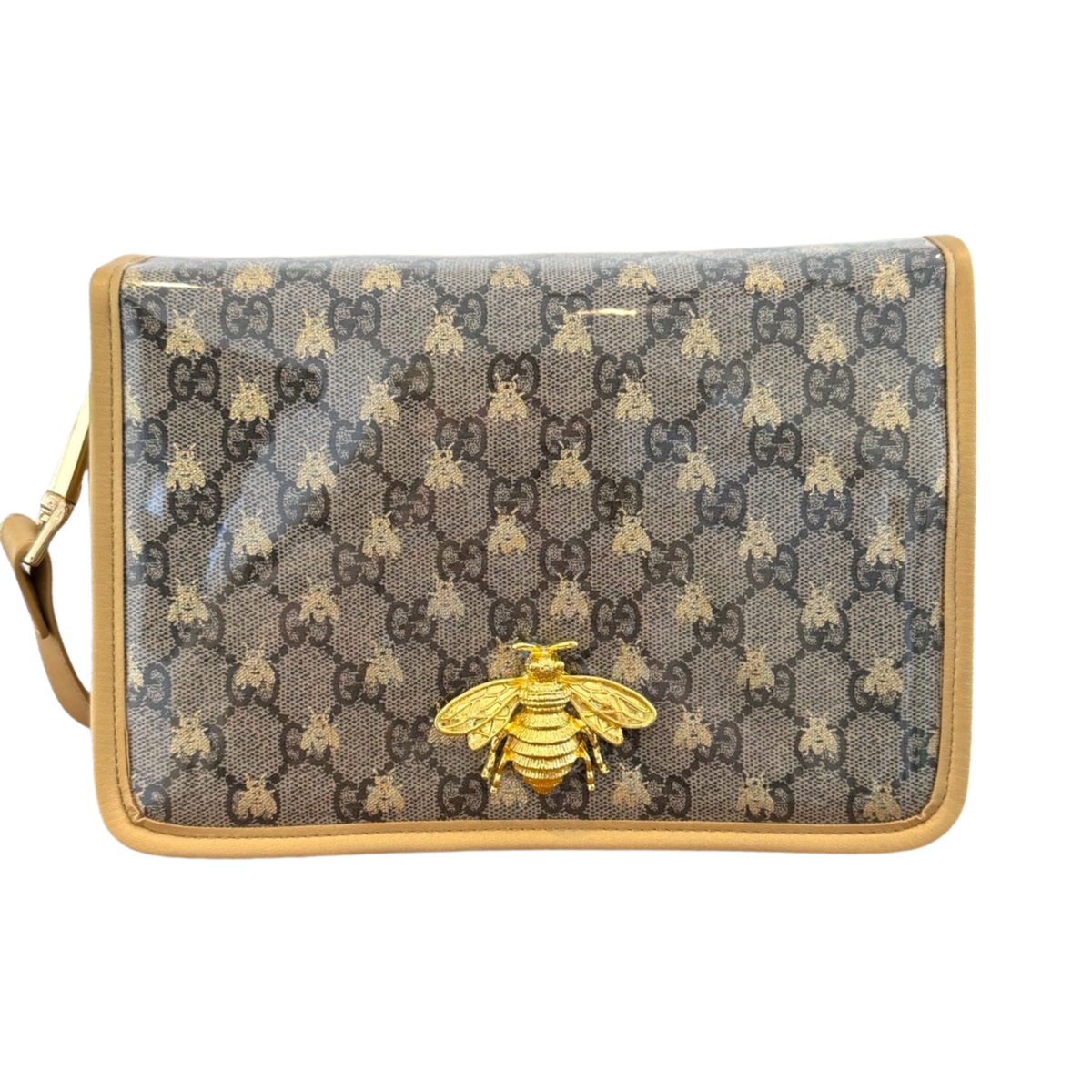 A Gucci shoulder bag in GG Supreme canvas with a glossy finish, featuring a gold-tone bee charm on the front and a tan leather trim.