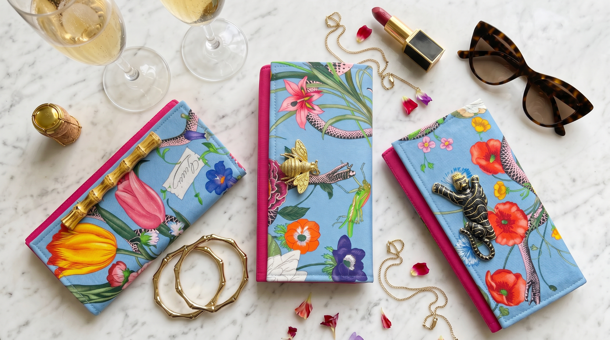 Colorful jewelry boxes with floral designs on a marble surface with accessories.